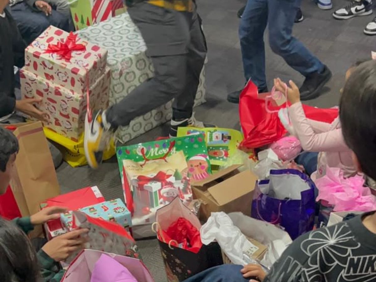 Niñas y niños de la casa hogar abriendo los regalos de su apadrinamiento