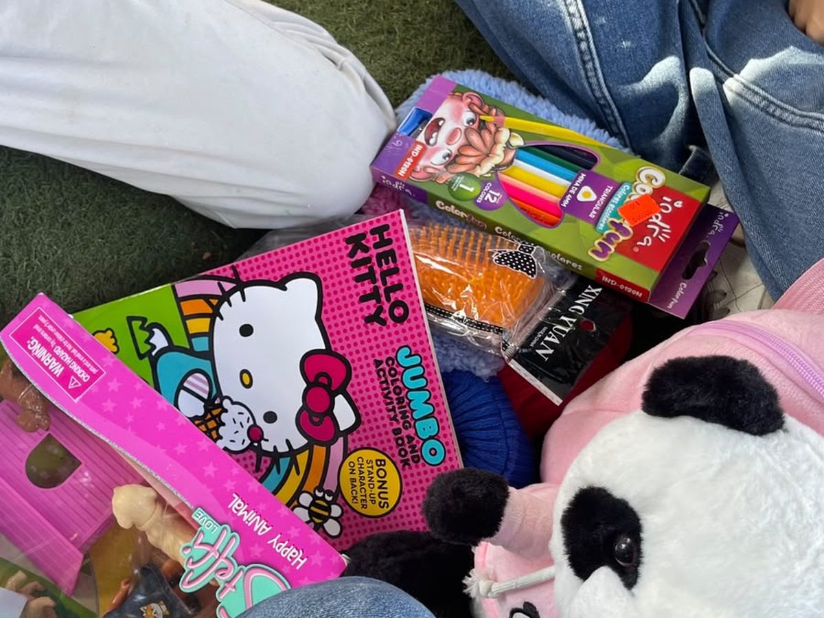 Paquete de juguetes, peluche y material para dibujar entregado a una niña